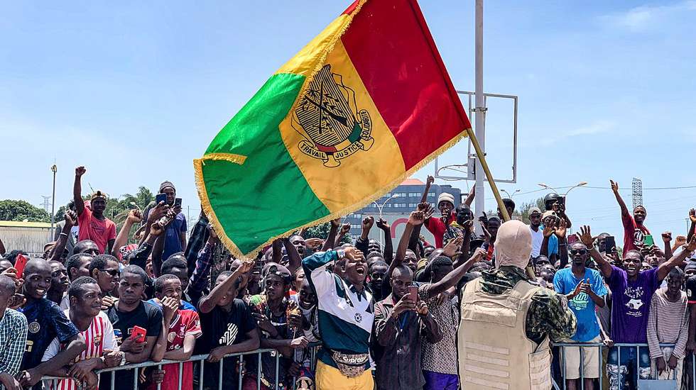 epa09452093 Guinean special forces celebrate with Guineans waving the national flag during celebrations at the Palace of the People in Conakry, Guinea, 06 September 2021. A meeting with the ministers of the Ex-President of Guinea was held 06 September 2021 after Guinea's President Alpha Conde was detained by army special forces in Conakry on 05 September 2021. Guinea Colonel Mamady Doumbouya spoke on a state television broadcast saying President Alpha Conde was in custody.  EPA/STR