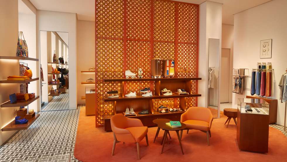 Uma divisória vertical do chão ao teto em forma de treliça separa as coleções de pronto a vestir feminina e masculina