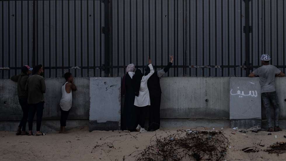 epa11290559 An Egyptian soldier (top) keeps watch as internally displaced Palestinians, who fled their homes due to the Israel-Hamas conflict, stand at the border with Egypt, in Rafah, southern Gaza Strip, 20 April 2024. Since 07 October 2023, up to 1.7 million people, or more than 75 percent of the population, have been displaced throughout the Gaza Strip, some more than once, in search of safety, according to the United Nations Relief and Works Agency for Palestine Refugees in the Near East (UNRWA), which added that the Palestinian enclave is 'on the brink of famine', with 1.1 million people (half of its population) 'experiencing catastrophic food insecurity' due to the conflict and restrictions on humanitarian access.  EPA/HAITHAM IMAD