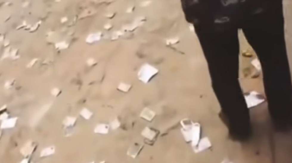 Captura de ecrã do vídeo onde se veem os cartões de eleitores espalhados na rua