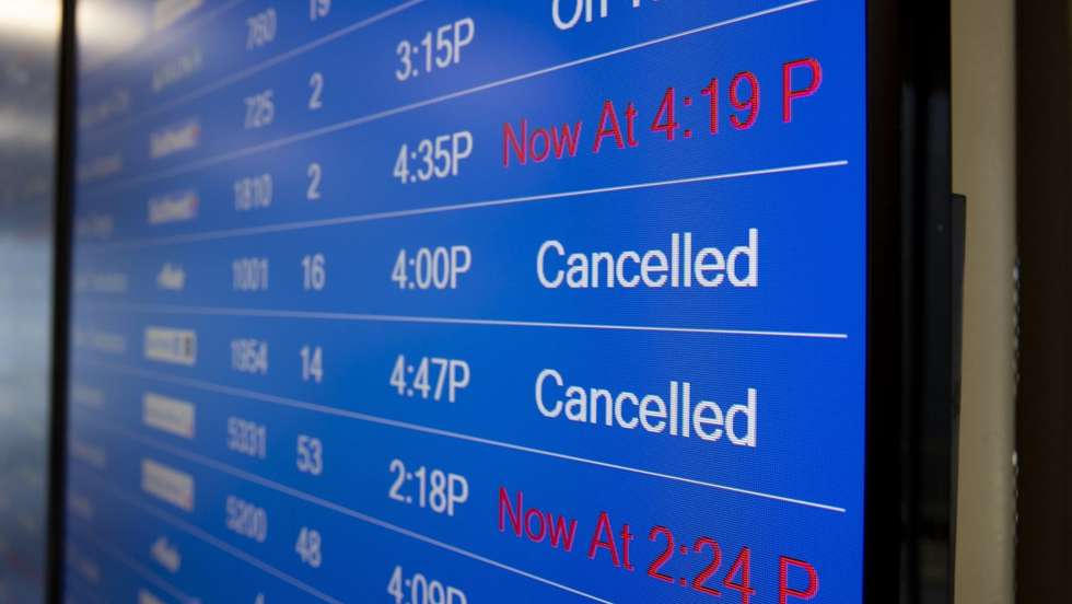 Painel informativo de voos com voos cancelados e atrasados.