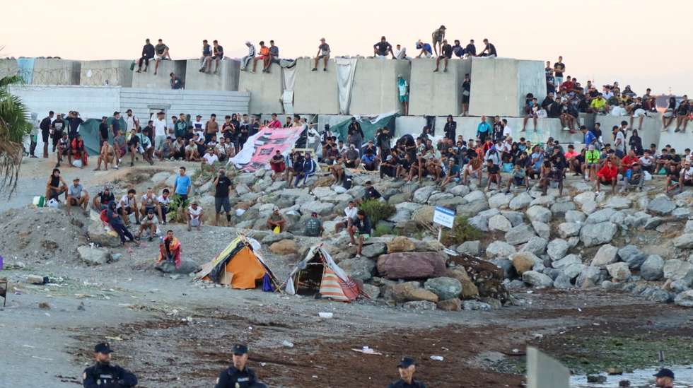 epa13197642 Migrants gather at an encampment as people take part in a rally protesting the migration crisis in Ceuta, Spain, 28 August 2026. The Ceuta Unida platform organized the protest.  EPA/REDUAN