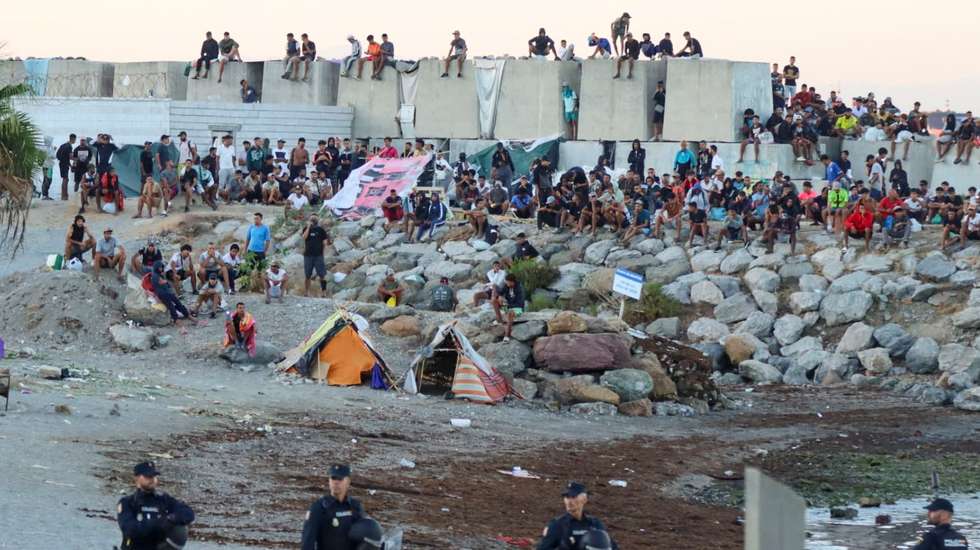epa13197642 Migrants gather at an encampment as people take part in a rally protesting the migration crisis in Ceuta, Spain, 28 August 2026. The Ceuta Unida platform organized the protest.  EPA/REDUAN