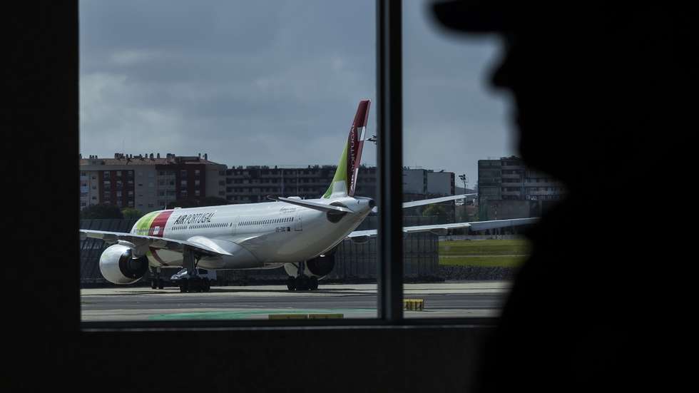 Um agente da Polícia de Segurança Pública observa um avião da TAP, no Aeroporto Humberto Delgado, em Lisboa, 15 de abril de 2025.  JOSÉ SENA GOULÃO/LUSA