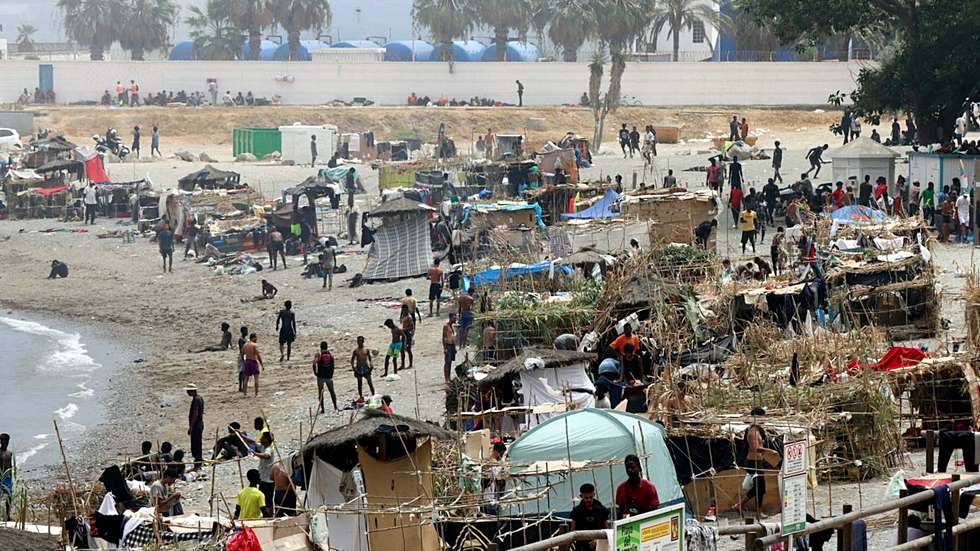 epaselect epa13169423 Migrants walk at Trampolin beach beach in Ceuta, Spain, 14 August 2026. Trampolin Beach in the Spanish North African enclave of Ceuta has undergone a rapid transformation: a small cluster of makeshift shelters less than a week ago has expanded to more than 80. According to police estimates, the beach is currently hosting around 1,500 migrants.  EPA/REDUAN