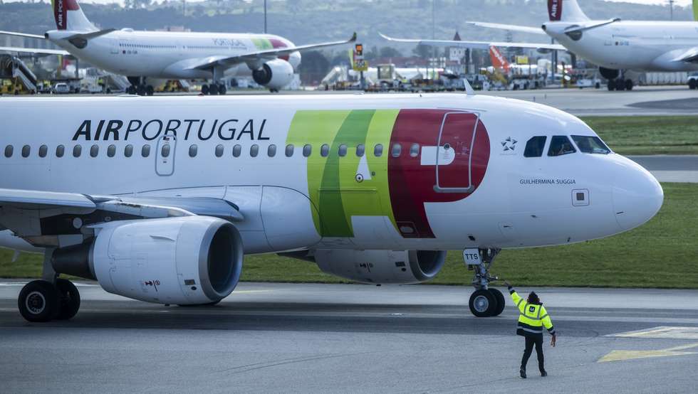 Um trabalhador de placa dá indicações a um piloto num avião da TAP, no Aeroporto Humberto Delgado, em Lisboa, 15 de abril de 2025.  JOSÉ SENA GOULÃO/LUSA