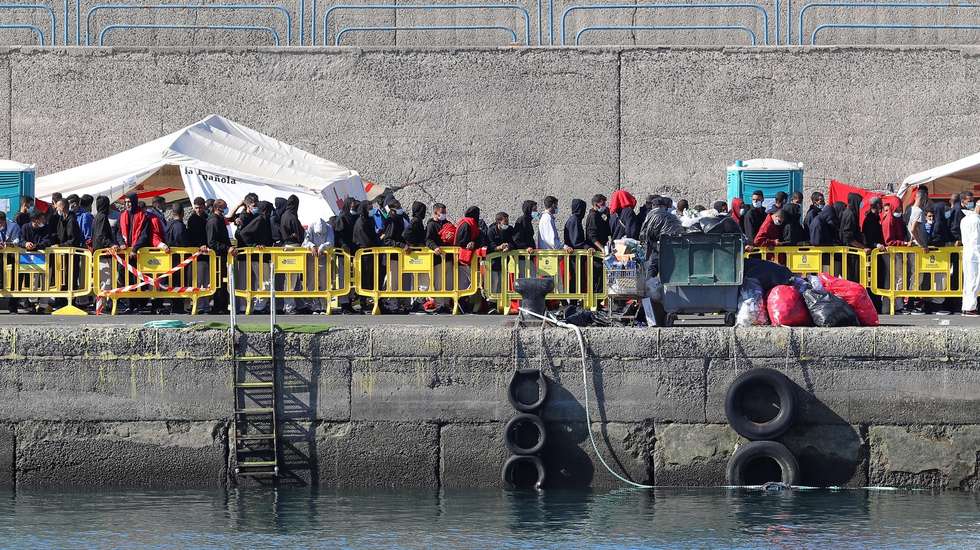 epa08807312 Migrants queue up to receive assistance at Arguineguin port in Gran Canarias, Spain, 08 November 2020. Almost 600 migrants traveling on board 21 toy boats were rescued between the late hours 07 November and the early ours of 08 November 2020. Almost 500,000 migrants have arrived to the Canary Islands throughout the year.  EPA/ELVIRA URQUIJO A.