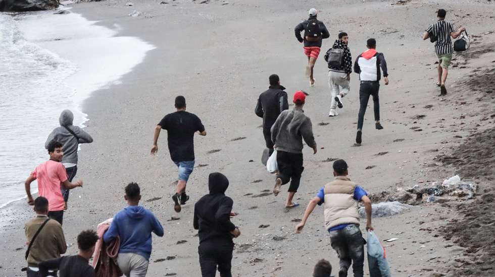 epa13269887 Immigrants run away form the National policemen that are dismantling the migrant camp at Playa Benitez in Ceuta, Spain, 29 September 2026. Spain is dealing with a massive migration crisis in the autonomous region of Ceuta after thousands of people crossed into the North African enclave from Morocco in late July 2026.  EPA/Reduan