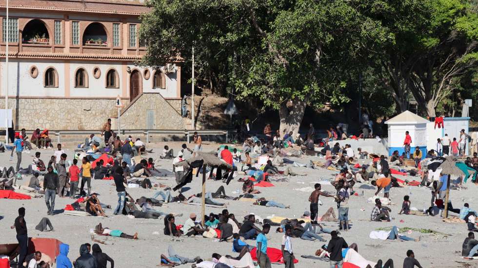 epa13149565 Young migrants who arrived in Ceuta a few days earlier stand on Trampolin Beach in Ceuta, Spain, 04 August 2026. About 2,500 migrants who crossed from Morocco remained in Ceuta, according to Spain's Government Delegation, with many sleeping rough and relying on humanitarian and community assistance for food as reception facilities remained overwhelmed.  EPA/REDUAN