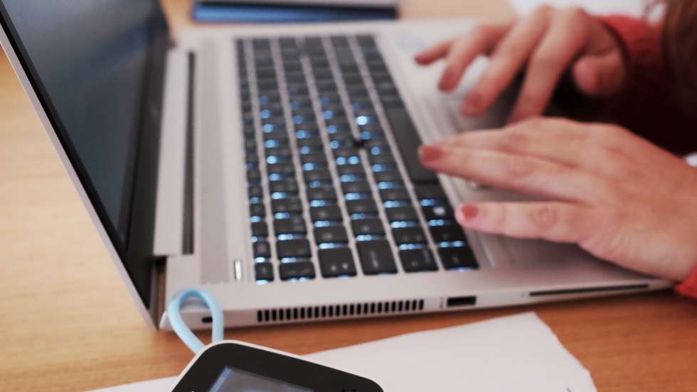 Uma mulher trabalha em casa como seu computador