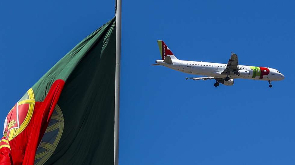 Um avião da TAP voa sobre uma bandeira de Portugal, no Parque Eduardo VII, em Lisboa, 10 de julho de 2023. JOSÉ SENA GOULÃO/LUSA