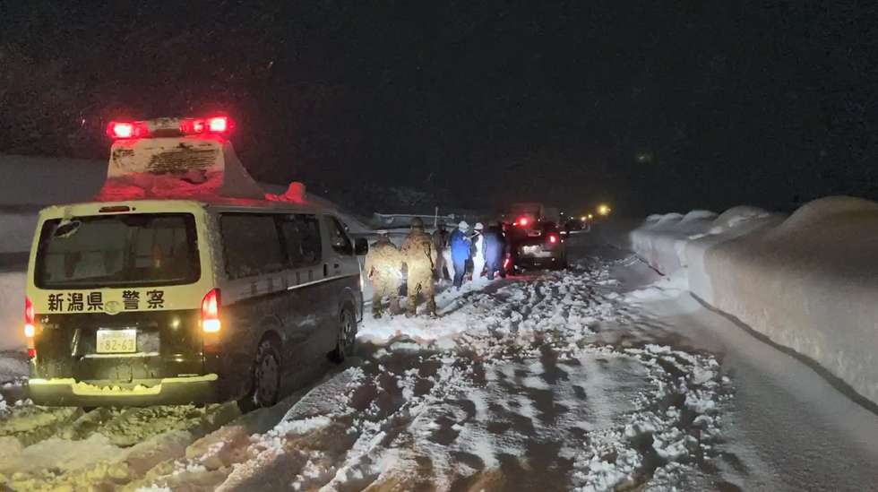 epa08891218 A handout photo made available by Japan's Defense Ministry Joint Staff via Jiji Press shows Japan's self-defense force personnel and police forces preparing help for vehicles stranded on the Kan-Etsu expressway near Yamato parking area in Minami-uonuma, Niigata prefecture, Japan, late 17 December 2020 (issued 18 December 2020). On 18 December 2020 afternoon, around 670 vehicles remained stranded on the Kan-Etsu highway due to heavy snow fall as Ground Self-Defense Force members still work on helping trucks and cars passengers.  EPA/JAPAN'S DEFENSE MINISTRY JOINT STAFF HANDOUT JAPAN'S DEFENSE MINISTRY JOINT STAFF /JAPAN OUT HANDOUT EDITORIAL USE ONLY/NO SALES