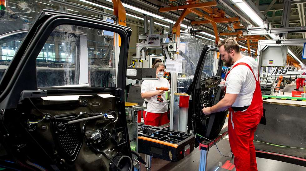 epa08388717 Workers wearing protective face masks resume the automobile production at Audi factory after an extended interruption during the ongoing coronavirus COVID-19 pandemic in Gyor, Hungary, 27 April 2020. In the first step, two thousand factory workers started their work in one shift. The vehicle assembly currently produces 250 cars per shift, and the company wants to gradually increase production in the coming weeks.  EPA/CSABA KRIZSAN HUNGARY OUT