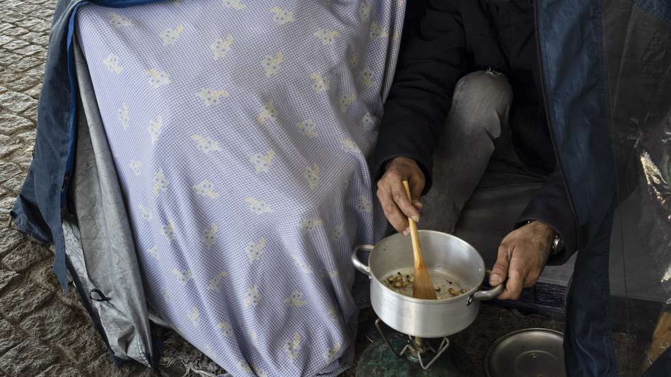 Hermínio Guedes, 46 anos, prepara uma refeição na tenda onde vive no bairro das Fontainhas, no Porto, 31 de janeiro de 2023. Quando na cidade do Porto se junta doenças, falta de habitação, temperaturas quase negativas e enxurradas, o resultado é uma espécie de revolução dos sem-abrigo a montar tendas iglu para combater a vaga de frio no Norte de Portugal. (ACOMPANHA TEXTO DA LUSA DO DIA 05 DE FEVEREIRO DE 2023). JOSÉ COELHO/LUSA