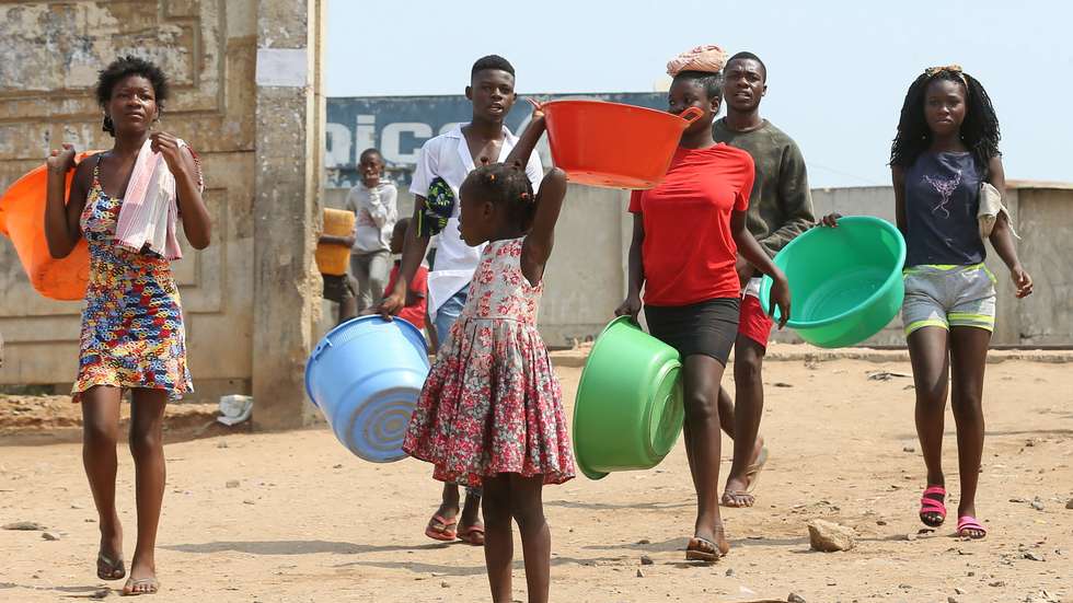 Crianças, jovens e adultos, em Luanda, "lutam", numa tubagem pública, por eles "danificada", à berma da estrada, para conseguir uma banheira ou balde de água que, há semanas, não jorra naquela circunscrição do município do Cazenga, 21 junho 2021. (ACOMPANHA TEXTO DO DIA 25 JUNHO 2021).  AMPE ROGERIO / LUSA