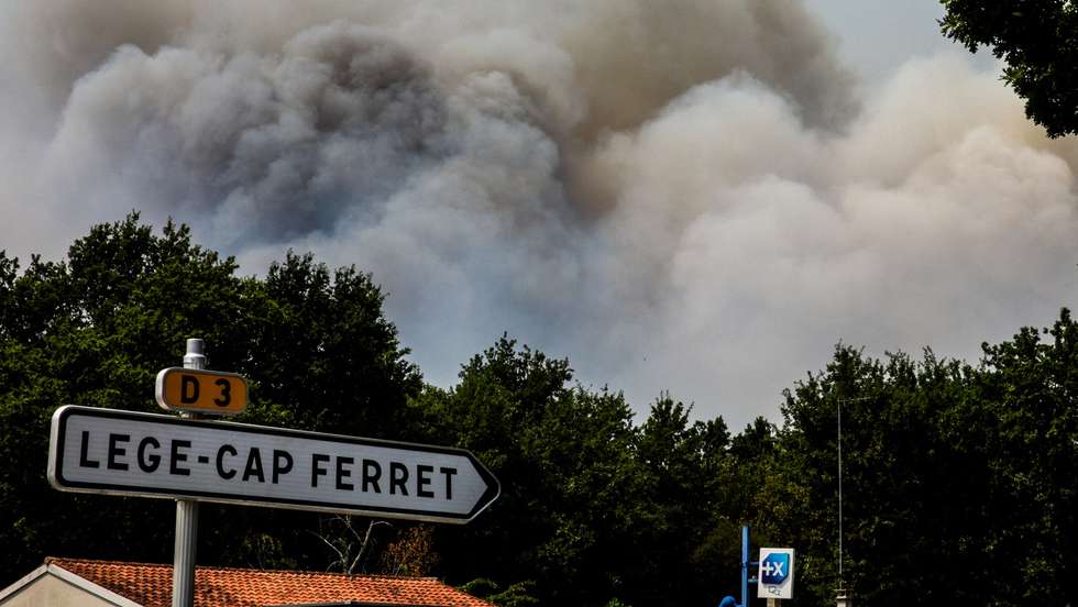 epa13130642 Smoke rises over a pine forest during a wildfire spreading in Cap Ferret, in Lege-Cap-Ferret, south-western France, 24 July 2026. French Interior Minister Laurent Nunez confirmed that around 40,000 people are being evacuated from the Cap Ferret peninsula due to the wildfires following a total evacuation order issued by authorities for the southwestern region.  EPA/JULIEN REGUL