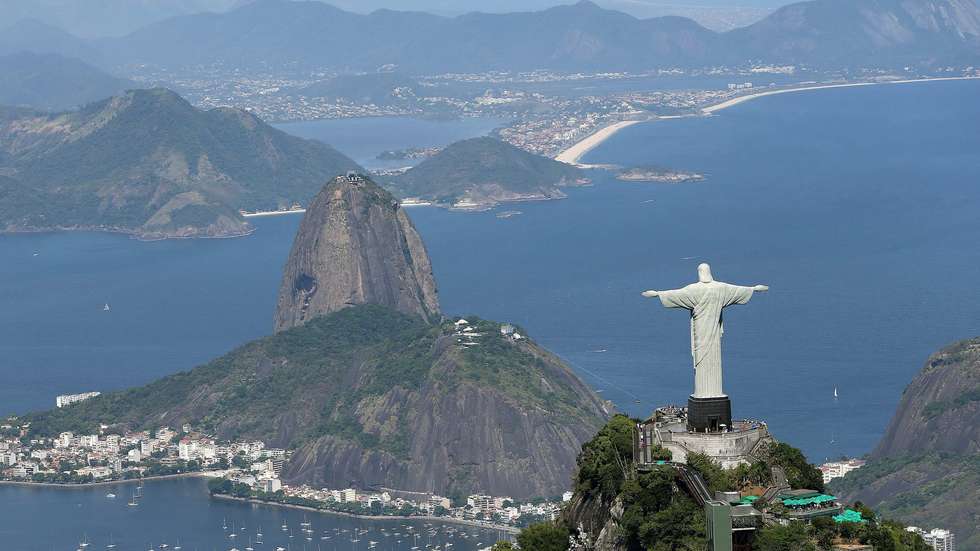 epa09520096 (FILE) - An aerial view of the Christ the Redeemer (Cristo Redentor) statue atop Corcovado Mountain overlooking the city towarss Sugarloaf Mountain (Pao de Acucar hill, C) in Rio de Janeiro, Brazil, 07 February 2014 (reissued 12 October 2021). The 'Marvellous City' is celebrating the 90th anniversary of Rio's Christ the Redeemer statue's unveilling of 12 October 1931.  EPA/MARCELO SAYAO *** Local Caption *** 51299671