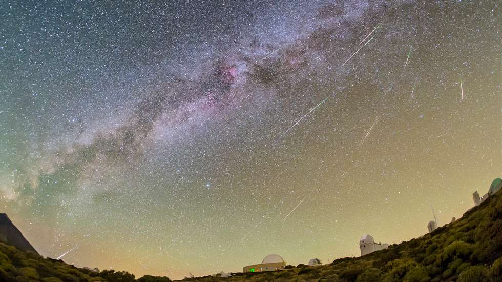 Algunas de las Perseidas capturadas la noche del 11 al 12 de agosto de 2021 desde el Observatorio del Teide (Instituto de Astrofísica de Canarias). En la imagen, la Vía Láctea divide el cielo con una diagonal que parece conectar el pico del volcán Teide (en la isla de Tenerife), con el radiante de esta lluvia de meteoros, la constelación de Perseo, que apenas se aprecia debido a la densidad de estrellas que pueblan el cielo. En el extremo izquierdo de la mitad superior destaca Júpiter. También muy brillante, debajo de él, le acompaña Saturno. Mucho más a su derecha, casi en el límite superior de esta composición, un óvalo difuso revela la presencia de la galaxia de Andrómeda. Otro de los objetos que reclaman protagonismo es la estrella Vega, la candela de los astrónomos. Esta estrella es utilizada como referencia por los científicos, llegando a considerarse la más importante del cielo después del Sol. En el plano terrestre, sobre la vegetación característica de esta zona de preparque, se distinguen el perfil de la Pirámide solar y las cúpulas de los telescopios IAC80, OGS, ELRS (ESA Laser Ranging Station), los telescopios solares VTT y GREGOR; y QUIJOTE. Crédito: M. R. Alarcón y D. Padrón.