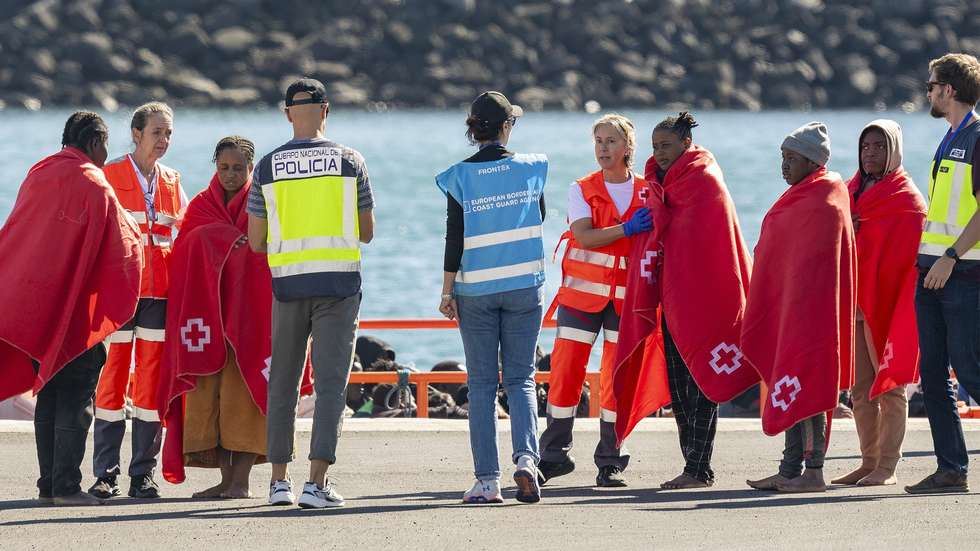 epa11803774 A Spanish police officer (C-L) and a Frontex officer (C-R) receive migrants upon their arrival at the port of the town of Arrecife, in Lanzarote island, after a boat with over 50 migrants on board was rescued by a Spanish Sea Rescue Unit' ship off Lanzarote island's coast, Canary Islands, southwestern Spain, 03 January 2025.  EPA/Adriel Perdomo