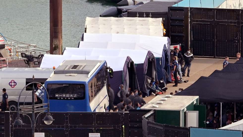 epa10199368 Migrants are processed after disembarking a Border Force vessel carrying migrants rescued in the English Channel, at Dover Dock, Dover, Britain, 22 September 2022. According to the British Ministry of Defence, more than 30,000 people crossed the English Channel on small boats since the beginning of the year, making the provisional number of arrivals as of September 2022, higher than the total of 2021.  EPA/STUART BROCK