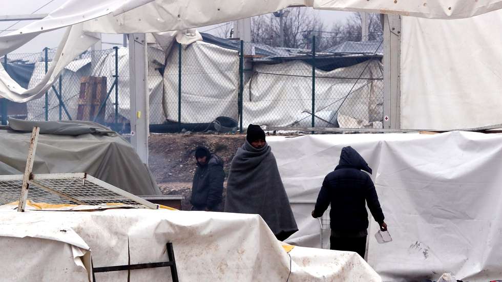 epa08914431 Migrants walk among smoke during a winter day at the Lipa refugee camp outside Bihac, Bosnia and Herzegovina, 01 January 2021. Some thousand refugees at the camp were scheduled to be relocated from the burnt-down tent camp on 31 December, yet were returned to Lipa camp. A fire on 23 December destroyed most of the camp near the city of Bihac, which has already been sharply criticized by international authorities and aid groups as unsuitable for accommodating refugees and migrants.  EPA/FEHIM DEMIR