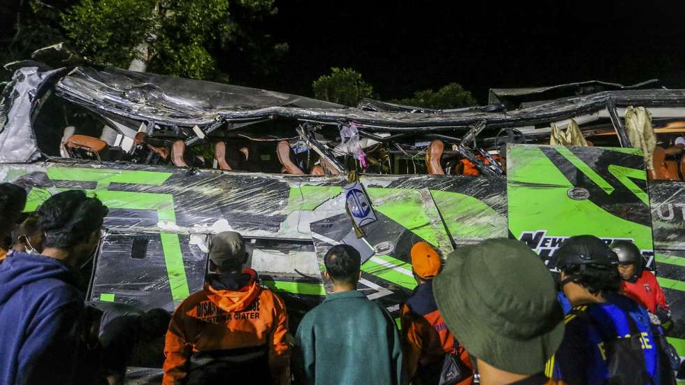 epa11334420 Police officers and rescuers inspect the wreckage of a bus after a crash in Subang, West Java, Indonesia, 11 May 2024. At least 11 people were killed when a bus with dozens of high school students on board crashed while on a graduation trip in West Java province.  EPA/RYAN SUHERLAN