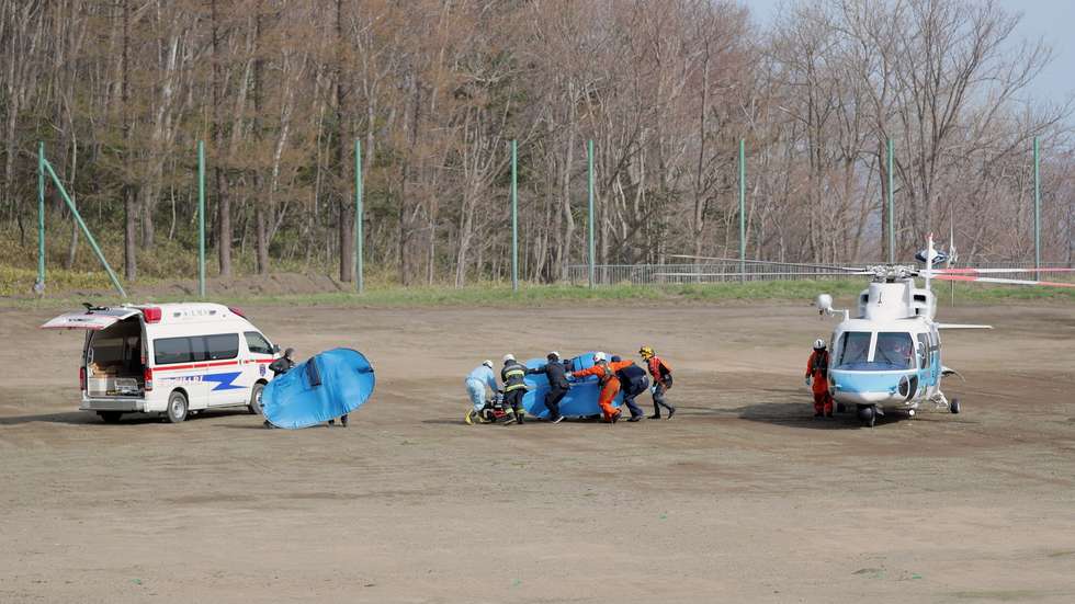 epa09905582 Rescue workers take an unconscious person from a Japan Coast Guard helicopter to an ambulance at Utoro in Shari, Hokkaido island, Japan, 24 April 2022, after a tour boat with 26 people was missing 23 April 2022. The boat went missing off the western coast of the Shiretoko Peninsula in Hokkaido, a northern Japanese island. The Japan Coast Guard announced they found three people at sea and one on the tip of the peninsula in the early morning of 24 April 2022.  EPA/JIJI PRESS JAPAN OUT EDITORIAL USE ONLY/  NO ARCHIVES