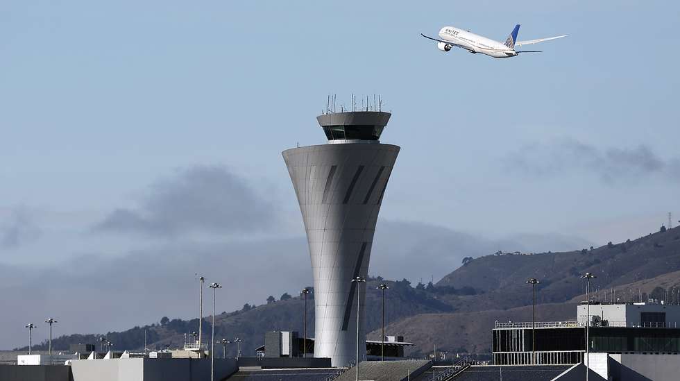 epa12511438 A United Airlines jetliner takes off at San Francisco International Airport (SFO) while passing the control tower as seen from Bayfront Park in Burlingame, California, USA, 07 November 2025. The Federal Aviation Administration (FAA) is currently implementing an order to reduce air traffic by 10 percent at 40 of the nation's busiest airports as a safety measure due to the ongoing government shutdown.  EPA/JOHN G. MABANGLO