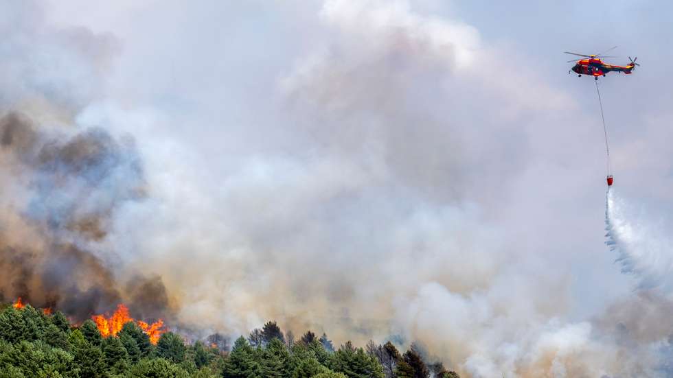 epa13123358 A helicopter pours water over a wildfire that started in La Mierla, Guadalajara, Spain, 20 July 2026. The forest fire is still not under control. Thirty-two towns have been evacuated so far, impacting approximately 1,200 residents.  EPA/Nacho Izquierdo