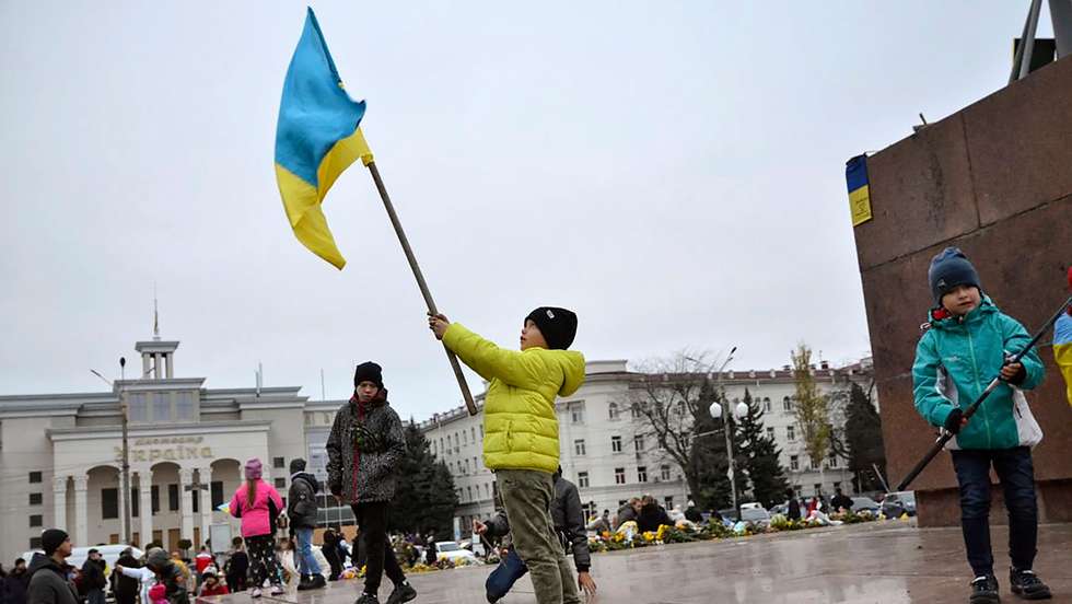 epa10303796 Children wave Ukrainian flags at the main square in the recently recaptured city of Kherson, Ukraine, 13 November 2022. Ukrainian troops arrived in Kherson on 11 November following the Russian troops' withdrawal from the city. Russian troops entered Ukraine on 24 February 2022 starting a conflict that has provoked destruction and a humanitarian crisis.  EPA/IVAN ANTYPENKO