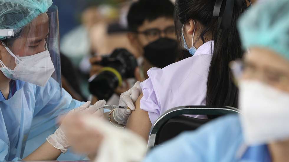 epa09504887 A health official administers a dose of Pfizer vaccine against COVID-19 to a student during the initiation of a COVID-19 vaccination drive for students at Pibool Uppatham School, in Bangkok, Thailand, 04 October 2021. Thailand rolled out a vaccination drive against COVID-19 for students aged 12-18 year-old with the Pfizer vaccine before school reopens. Thai authorities aim to reach 70 percent of its population vaccinated, a goal for safely opening the country under the 'living with COVID-19' strategy.  EPA/NARONG SANGNAK