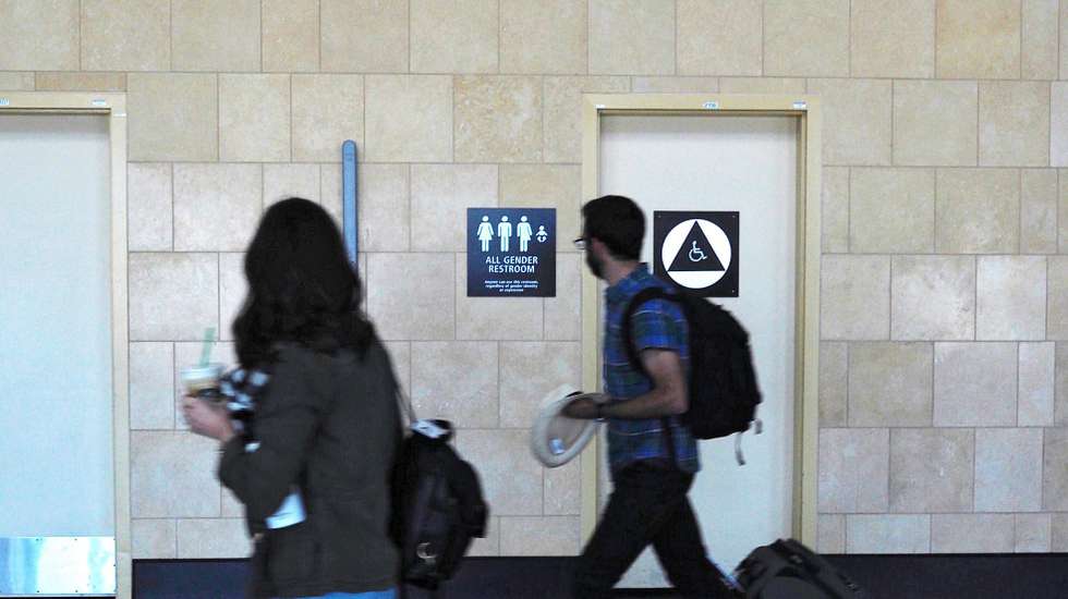 epa05303099 (FILE) A file picture dated 16 april 2016 shows two people walking past an 'All Gender' bathroom sign at the San Diego International Airport in San Diego, California, USA.  According to reports from 13 May 2016, the US administration plans to direct public schools to allow transgender students use whichever bathroom they prefer to match their gender identity.  EPA/JASON SZENES *** Local Caption *** 52706229