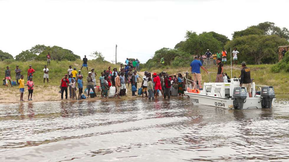 Locais aguardam por uma embarcação, durante as cheias que atingem a Macaneta, arredores de Maputo, 23 de janeiro de 2026. Antes zona turística, na Macaneta, arredores de Maputo, barcos a motor e a remos abrem caminho para salvar centenas de famílias isoladas pelas cheias. Com a filha de um mês nas costas e outro pela mão, Isa pisa finalmente terra firme. LUÍSA NHANTUMBO/LUSA
