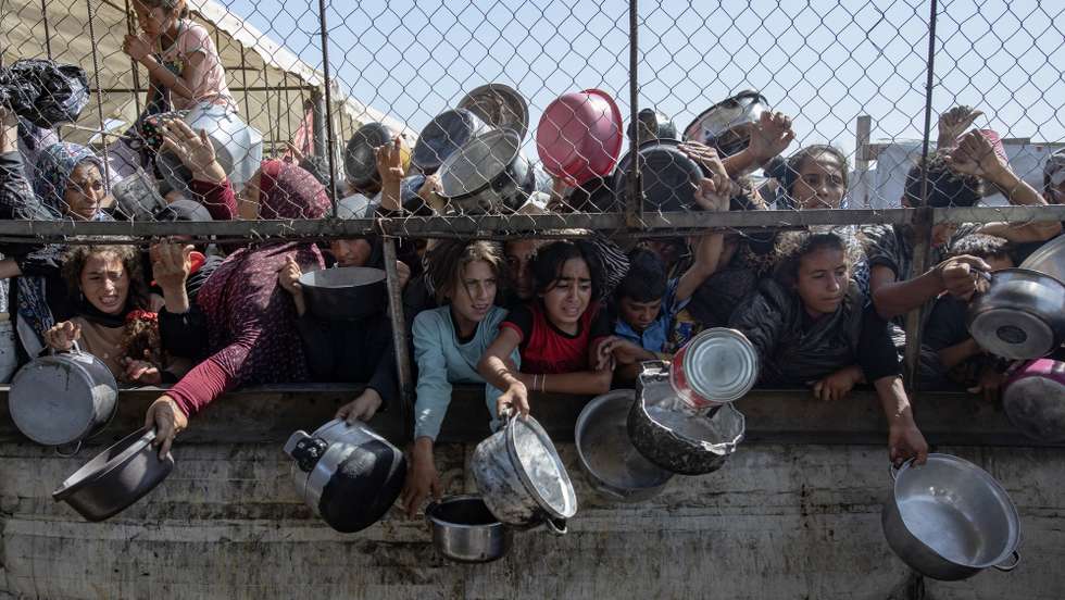 epa12144612 Internally displaced Palestinians gather outside a charity kitchen to receive limited rations amid a shortage of food, in Khan Younis, southern Gaza Strip, 30 May 2025. The United Nations has warned that "the entire population of Gaza is facing the risk of famine" since Israel closed border crossings on 02 March 2025, preventing the entry of essential supplies. The Gaza Government Media Office reported on 24 May that at least 58 people died due to malnutrition, and nearly 250 others due to a lack of food and medicine.  EPA/HAITHAM IMAD