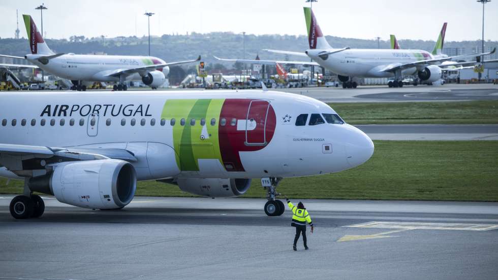 Um trabalhador de placa dá indicações a um piloto num avião da TAP, no Aeroporto Humberto Delgado, em Lisboa, 15 de abril de 2025.  JOSÉ SENA GOULÃO/LUSA