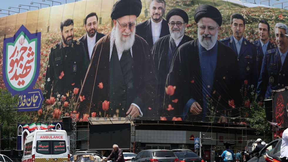 epa12980243 An Iranian worker pushes a cart in front of a large billboard displaying pictures of late Iranian supreme leader Ayatollah Ali Khamenei and late Iranian president Ebrahim Raisi at the Enghelab square in Tehran, Iran, 21 May 2026. Tensions between the US and Iran continue as a deal has not been reached.  EPA/ABEDIN TAHERKENAREH