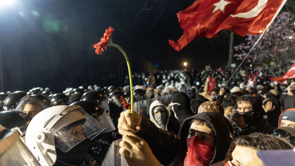 epaselect epa11986042 A protester holds a flower towards policemen during a march to Taksim Square from the Istanbul Municipality headquarters during a protest against the detention of Istanbul Mayor Ekrem Imamoglu in Istanbul, Turkey, 24 March 2025. Istanbul Mayor Ekrem Imamoglu of the Republican People's Party (CHP) was jailed and dismissed by the Turkish Ministry of Interior on 23 March on corruption charges following his detention on March 19 along with 100 others.  EPA/ERDEM SAHIN