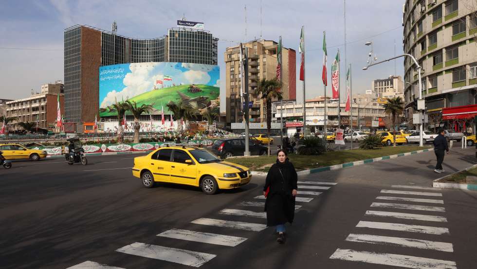 epa12737090 An Iranian woman walks past an anti-US billboard at Valiasr Square in Tehran, Iran, 14 February 2026, amid heightened regional tensions following an increased US military presence in the Middle East.  EPA/ABEDIN TAHERKENAREH