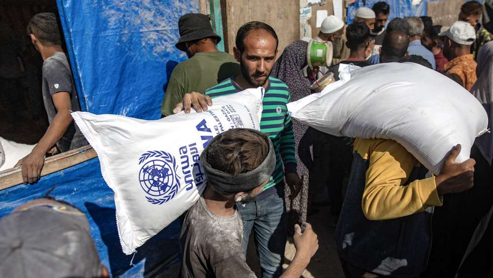 epa11693921 Palestinians carry bags of flour handed out by a United Nations Relief and Works Agency for Palestine Refugees in the Near East (UNRWA) aid distribution center in Khan Younis, southern Gaza Strip, 31 October 2024. According to the UN, at least 1.9 million people (or nine in ten people) across the Gaza Strip are internally displaced, including people who have been repeatedly displaced. Since October 2023, only about 11 percent of the Gaza Strip has not been placed under Israeli-issued evacuation orders, the UN aid coordination office OCHA said.  EPA/HAITHAM IMAD