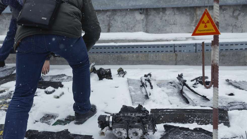 epa11896529 Ukrainian experts inspect debris near a damaged protective shelter over the remains of the reactor Unit 4 at the Chernobyl nuclear power plant (NPP), near the city of Chernobyl, Ukraine, 14 February 2025, amid the Russian invasion. Ukraine's President Zelensky said on 14 February, that a Russian drone with a 'high-explosive warhead' struck the shelter covering the destroyed Unit 4 of the Chernobyl NPP overnight. A fire was extinguished and radiation levels are being monitored at the site, Ukrainian authorities said.  EPA/SERGEY DOLZHENKO