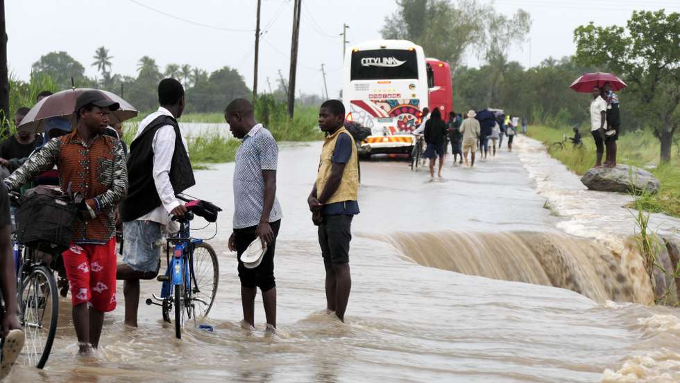 epa10522430 People walk on a road flooded by the River Bilila, Maputo, Mozambique, 14 March 2023. This is one of the longest lasting storms ever, after it formed at the beginning of February in the Asian seas, crossing the entire Indian Ocean to the east African coast. Until now 10 people have been killed by the storm according to official data.  EPA/ANDRÉ CATUEIRA