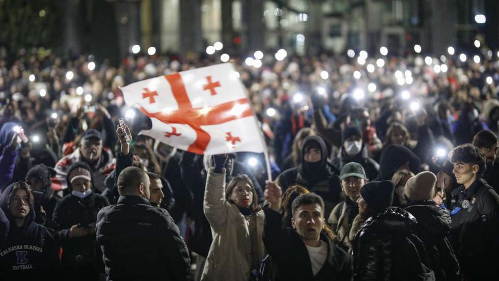 epa11755058 A Georgian opposition supporter waves Georgian flag during a protest in front of the Parliament building in Tbilisi, Georgia, 03 December 2024. Thousands of pro-EU activists continue their protests in the Georgian capital against the country's ruling party decision to suspend accession talks with the European Union (EU) until the end of 2028.  EPA/DAVID MDZINARISHVILI