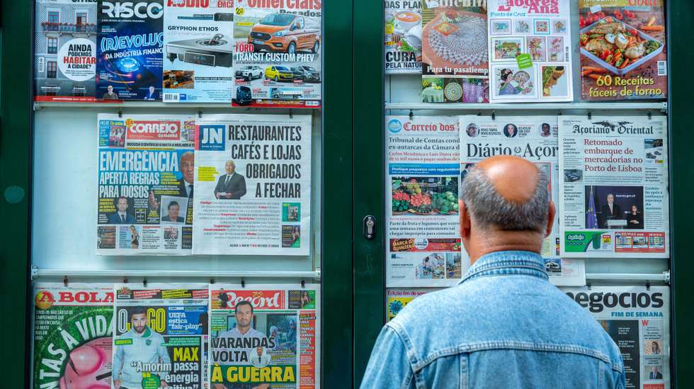 Um homem lê as capas dos jornais exposta na vitrina de um quiosque de rua em Ponta Delgada, ilha de São Miguel, Açores, 21 de março de 2020. Em Portugal, há 12 mortes e 1.280 infeções confirmadas. Portugal encontra-se em estado de emergência desde as 00:00 de quinta-feira e até às 23:59 de 02 de abril. EDUARDO COSTA/LUSA