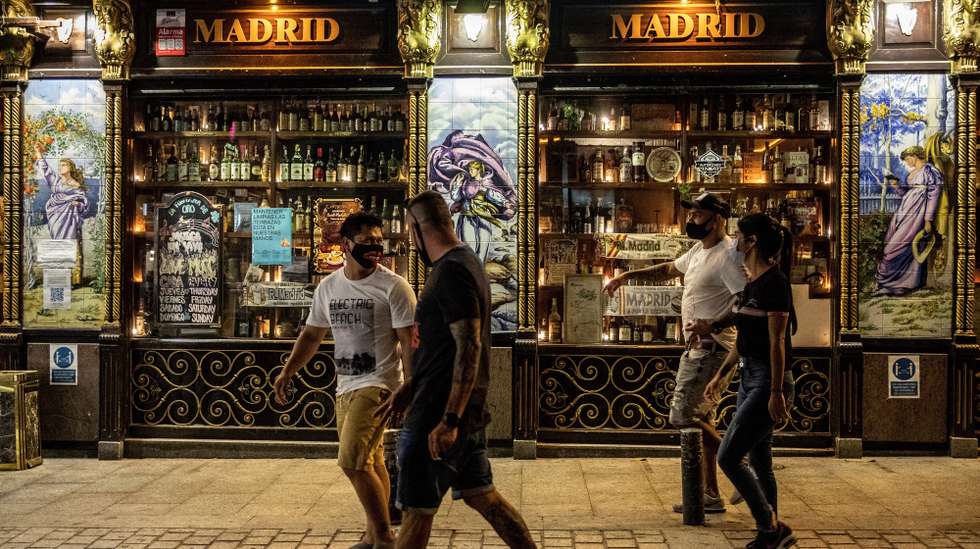 epa08610071 People walk past a bar in downtown Madrid, Spain, 17 August 2020 (issued 18 August 2020). The Spanish Government reached an agreement with all regional authorities on 14 August to take new measures to curb the spread of COVID-19, such as closing all night clubs or ban smoking in open-air public spaces.  EPA/RODRIGO JIMENEZ