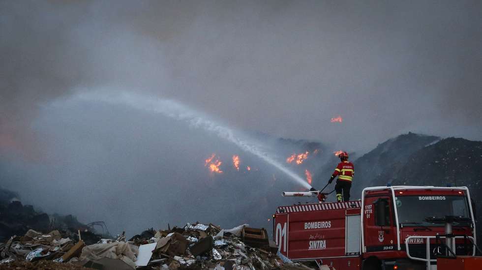 Um bombeiro combate um incêndio que deflagrou hoje à tarde na empresa Tratolixo, em Trajouce, no concelho de Cascais, 10 de julho de 2021. De acordo com fonte do Comando Distrital de Operações de Socorro (CDOS) de Lisboa, o alerta para o fogo na empresa de tratamento de resíduos sólidos Tratolixo, que entretanto se estendeu a uma zona de mato, foi dado às 16:15 e às 20:30 segundo a Autoridade Nacional de Emergência e Proteção Civil estão no terreno 154 operacionais , apoiados por 56 veículos. RODRIGO ANTUNES/LUSA