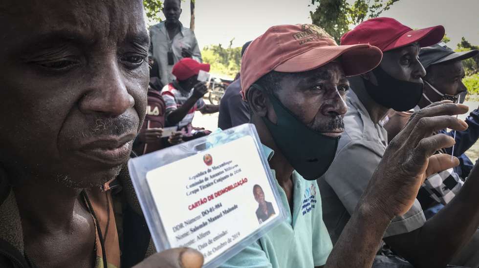 Ex-guerrilheiros exibem o seu cartão de desmobilização, durante uma reunião de ex-guerrilheiros desmobilizados na aldeia de Nhamatanda, Moçambique, 24 de maio de 2021. O Presidente moçambicano tem feito um balanço positivo do processo de DDR, em diferentes discursos feitos nas últimas semanas e destacou os "importantes avanços na implementação do processo, com 10 bases desativadas e 2.307 combatentes a entregar as armas, o equivalente a 44% do número total de guerrilheiros a desarmar”. (ACOMPANHA TEXTO DA LUSA DO DIA 25 DE MAIO DE 2021). ANDRÉ CATUEIRA/LUSA