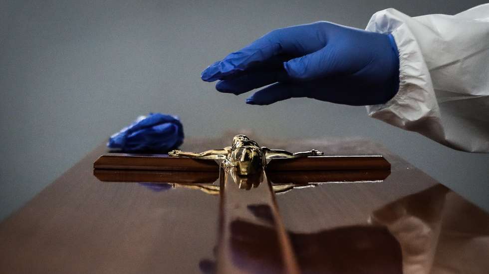 CONJUNTO DE 30 FOTOGRAFIAS SOBRE UM ANO DE ESTADO DE EMERGÊNCIA: 20-30: Foto datada de 30/01/2021: Um funcionário de uma agência funerária coloca uma imagem de Jesus Cristo em um caixão de uma mulher que morreu vítima de covid-19, na Amadora, 30 de janeiro de 2021. Esta semana Portugal ultrapassou as 300 mortes diárias por covid-19, um novo máximo desde o início da pandemia. MÁRIO CRUZ/LUSA