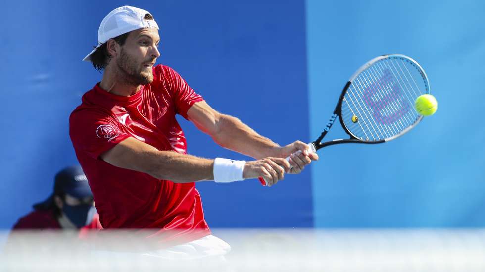 O tenista português João Sousa em ação durante o jogo de pares da primeira ronda do torneio dos Jogos Olímpicos Tóquio2020, Tóquio, Japão, 24 de julho de 2021. Pedro Sousa e João Sousa foram eliminados pelos japoneses Kei Nishikori e Ben McLachlan 6-1,6-4. JOSÉ COELHO/LUSA