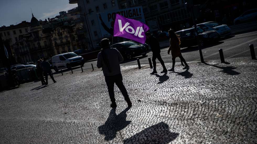 Um apoiante do Volt com uma bandeira do partido durante uma ação de campanha para as eleições legislativas de 2022 em Lisboa, 27  de janeiro de 2022. A 30 de janeiro mais de 10 milhões de eleitores residentes em Portugal e no estrangeiro constam dos cadernos eleitorais para a escolha dos 230 deputados à Assembleia da República. JOSÉ SENA GOULÃO/LUSA