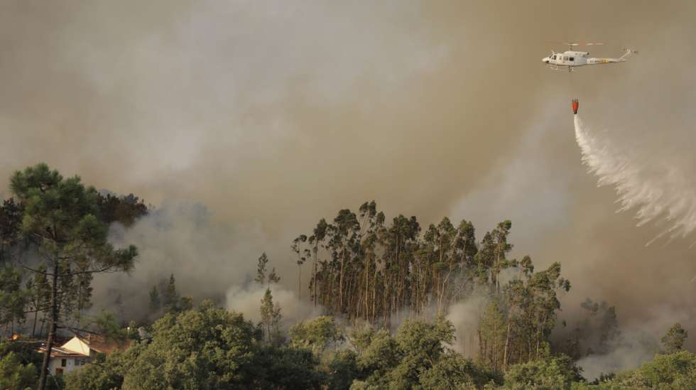 Um helicóptero combate um incêndio em Quebrada de Baixo, freguesia de Freixianda, concelho de Ourém, 09 de julho de 2022. O ministro da Administração Interna destacou hoje a "capacidade de fiscalização" mobilizada no combate aos incêndios, após ter sobrevoado os fogos de Carrazeda de Ansiães e de Ourém, a bordo de uma aeronave P-3C Cup+ da Força Aérea. PAULO CUNHA/LUSA